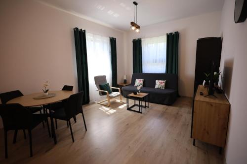 una sala de estar con un sofá y una mesa en Apartamenty Stronie - Polna Przystań, en Stronie Śląskie
