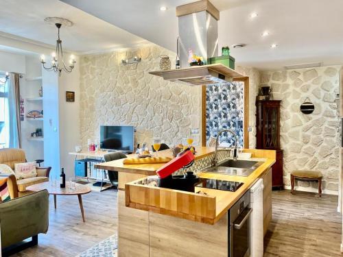 une cuisine avec un évier et un salon dans l'établissement Le Splendide YourHostHelper, à Nice