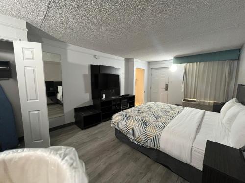 a hotel room with a bed and a desk at Studio 6 Phoenix, AZ Midtown in Phoenix