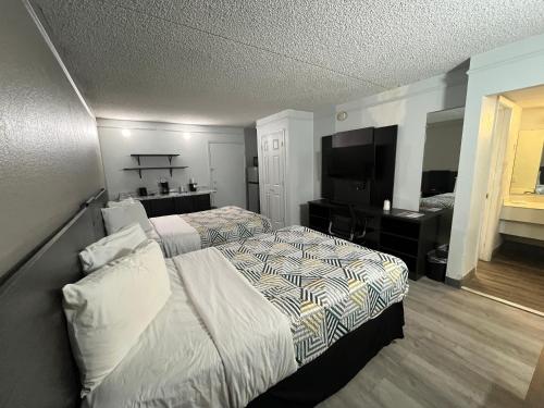 a hotel room with two beds and a flat screen tv at Studio 6 Phoenix, AZ Midtown in Phoenix