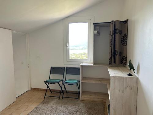 Cette chambre dispose de deux chaises, d'un bureau et d'une fenêtre. dans l'établissement Villa vue mer exceptionnelle à 500m de la plage de Santa Giulia, à Porto-Vecchio
