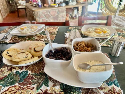 uma mesa com pratos de comida e tigelas de comida em Hermoso y único chalet Duplex en Guarame, full equipo, con piscina privada y vistas a tan solo 2 minutos de playa Guacuco em Guarame