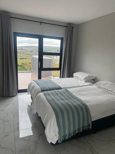 Un dormitorio con una cama grande y una ventana grande. en 955 Highlands Gate Golf Estate, en Dullstroom