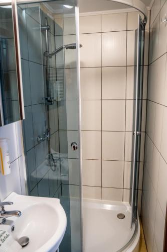 a bathroom with a glass shower and a sink at Pokoje Gościnne Na Szlaku in Krościenko