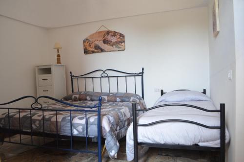 2 aparte bedden in een kamer met witte muren bij Trullo Levante Valle d'Itria in Cisternino