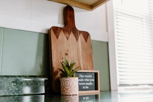 a wooden cutting board sitting next to a potted plant at Spacious Home Near Lake MI w Fire Pit in Sheboygan