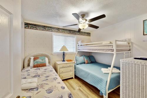une chambre avec deux lits superposés et un ventilateur de plafond dans l'établissement Hilton Head Resort 2103, à Île de Hilton-Head