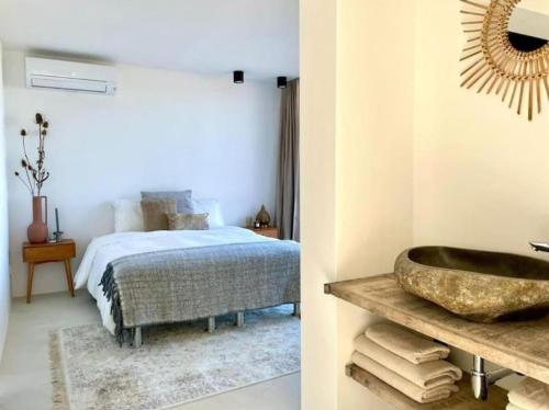 Un dormitorio con una cama y un baño con lavabo. en Villa CAN YUCA, en Illes Balears