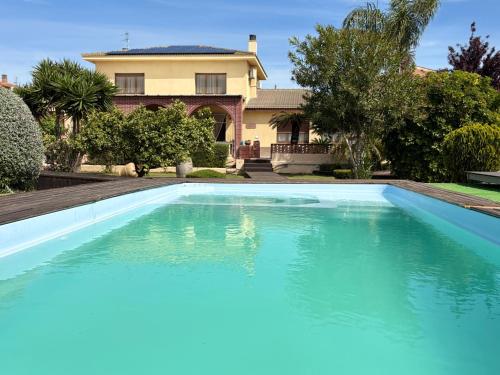a large blue swimming pool in front of a house at Villa Paquita - Delta de l'Ebre in Deltebre