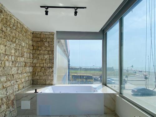 a bath tub in a room with a large window at Muralla by Wynwood House in Cartagena de Indias