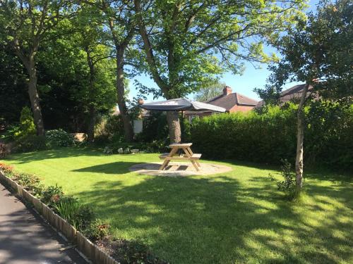 a picnic table with an umbrella in a yard at The Clifton Hotel Newcastle in Newcastle upon Tyne