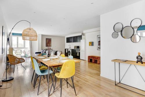 une salle à manger et un salon avec une table et des chaises dans l'établissement Sejour elegant aux Buttes Chaumont pour 12 pers, à Paris
