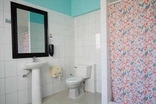 a bathroom with a toilet and a sink and a mirror at Hostal Providencia in Santiago