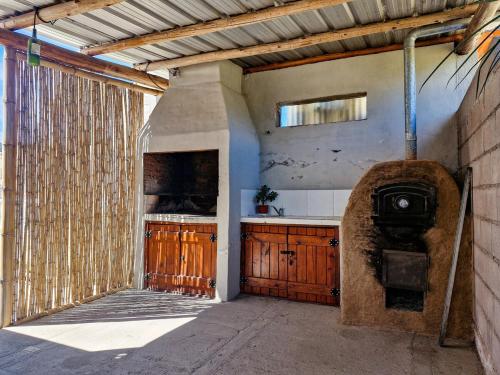 - une cuisine avec évier et cuisinière dans un bâtiment dans l'établissement Cabaña Pacha Munaskka con vista al lago, à El Mollar