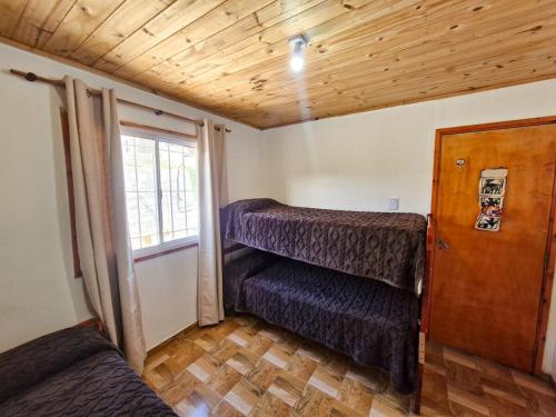 une petite pièce avec un lit et une fenêtre dans l'établissement Cabaña Pacha Munaskka con vista al lago, à El Mollar