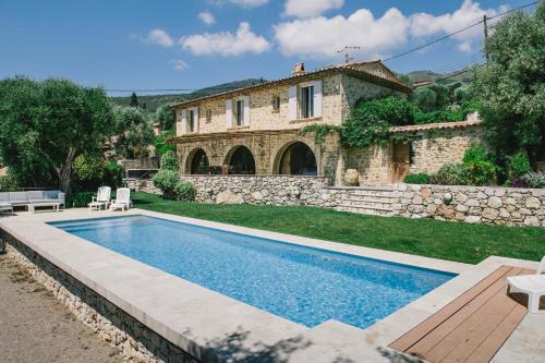 une villa avec piscine devant une maison dans l'établissement villa provençale en pierre avec vue sur la mer, piscine et jacuzzi, à Tourrettes-sur-Loup