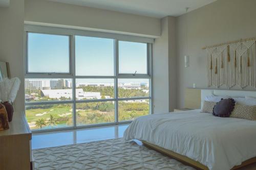 a bedroom with a bed and a large window at Beautiful Seibal Stay w Vidanta Resort Access in Nuevo Vallarta 