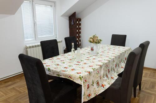 a dining room table with black chairs and a tablecloth on it at Bubamara house in Belgrade