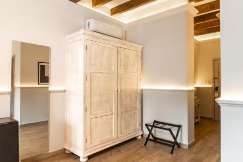 a large wooden cabinet in a room with a chair at voco Royalty Puebla Downtown by IHG in Puebla