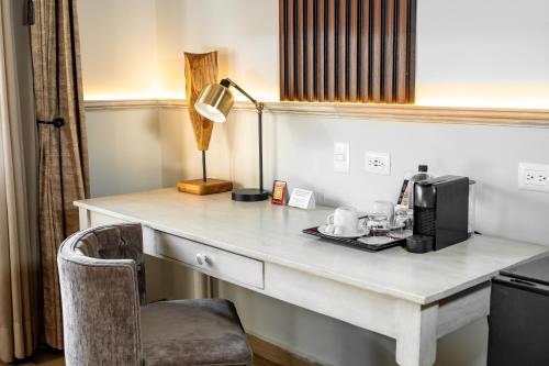 a desk with a coffee maker and a lamp on it at voco Royalty Puebla Downtown by IHG in Puebla