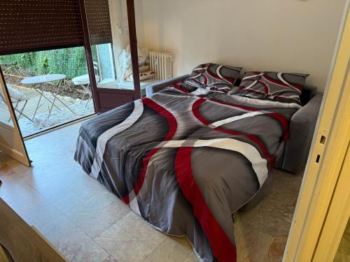łóżko z kolorową kołdrą w sypialni w obiekcie Studio calme à deux pas de la mer avec jardin et parking privé w mieście Beaulieu-sur-Mer