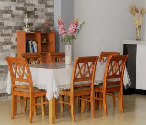 a dining room table with chairs and a vase of flowers at Ayllu in Huaraz
