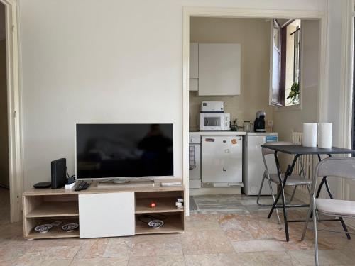 un salon avec une télévision à écran plat sur un meuble dans l'établissement Studio calme à deux pas de la mer avec jardin et parking privé, à Beaulieu-sur-Mer