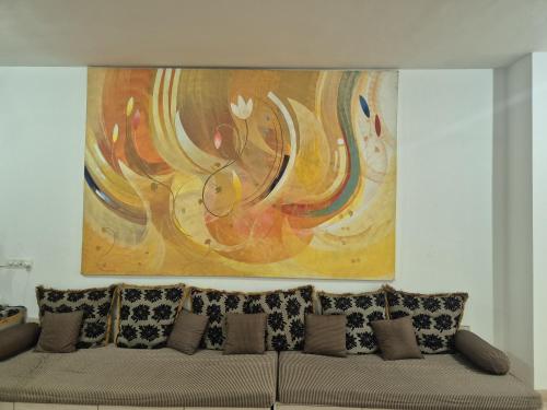 a painting above a couch in a living room at Elite Stays -Viman Nagar in Pune