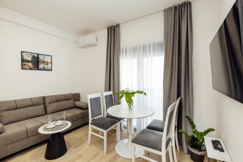 a living room with a couch and a table and chairs at Apartments Ivo Herceg Novi in Herceg-Novi