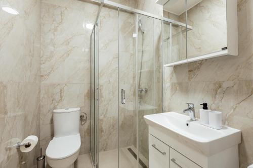 a bathroom with a shower and a toilet and a sink at Apartments Ivo Herceg Novi in Herceg-Novi