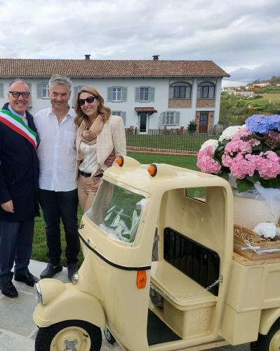 a group of three people standing next to a scooter at Dimora Relax in Costigliole dʼAsti
