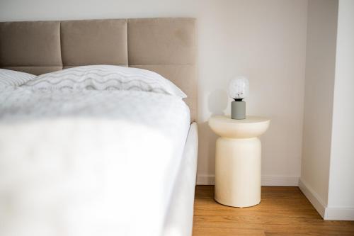 a bed with a white bedspread and a candle on a table at Apartmán Blue Wave in Banka