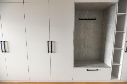 a white closet with white cabinets in a room at Apartmán Blue Wave in Banka