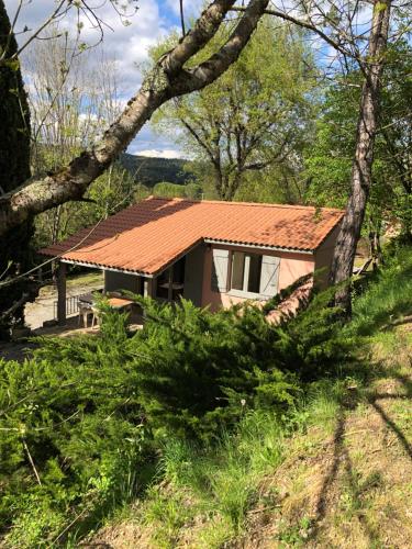 a house with a tiled roof in the woods at Manoir de Champvert in Les Vans