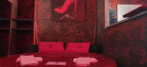 a red bedroom with a red bed with pink pillows at L'H LION's RED SUITE in Castrovillari