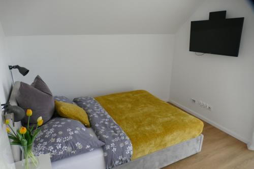 a living room with a couch with a yellow blanket at Ceglany Domek z jacuzzi, nad jeziorem, przy lesie in Tomaszkowo
