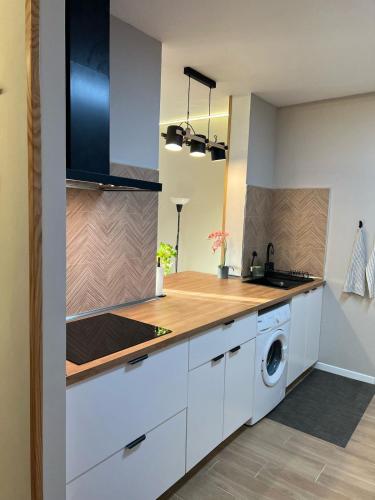 a kitchen with white cabinets and a washer and dryer at Oasis del Puerto Spacious Premium Apartment in Puerto de la Cruz