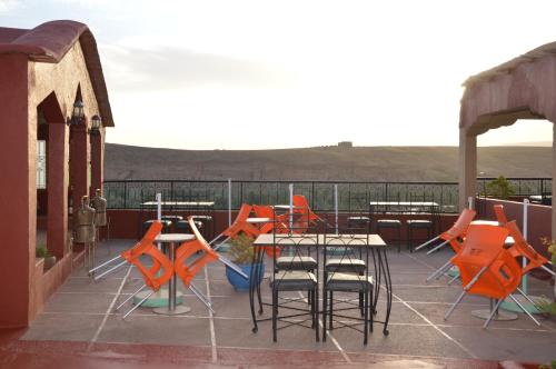 a patio with tables and chairs on a roof at Kasbah Tasseurte in Kalaat MGouna