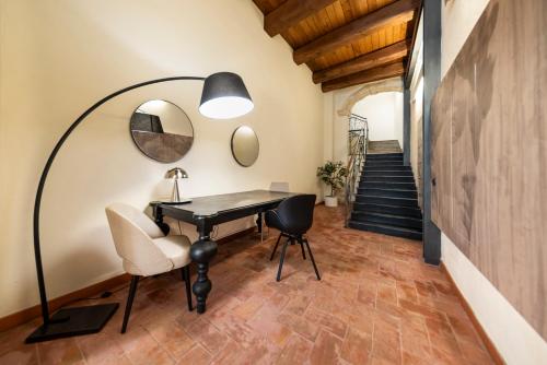 a room with a desk and chairs and a staircase at Suite Deluxe in Palazzo Storico - Centro Sassari - Appartamento Sassari in Sassari