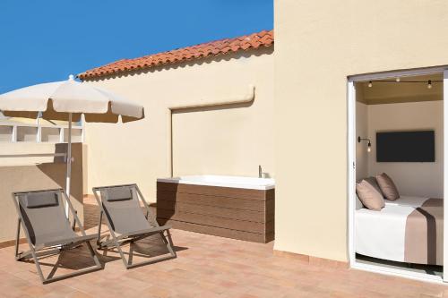 a patio with two chairs and a sink and a bed at tent Capi Playa in Playa de Palma