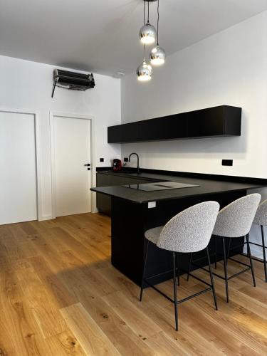 une cuisine avec un comptoir noir et deux chaises dans l'établissement Appartement Cosy - Rue Fesch, Tout à pied, à Ajaccio