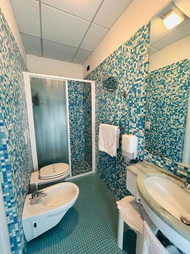 a bathroom with a sink and a toilet at Hotel Milano in Cesenatico