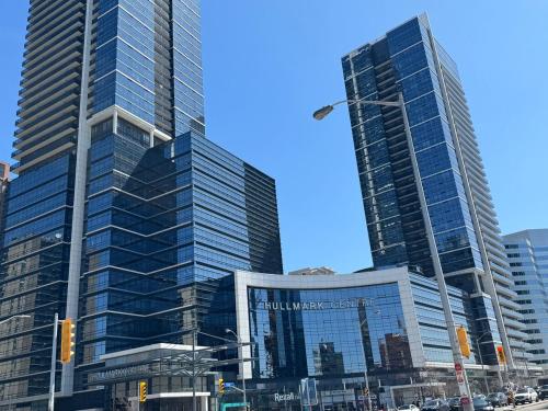 two tall skyscrapers in a city with a street at Condo at Yonge-Sheppard Station, North York in Toronto