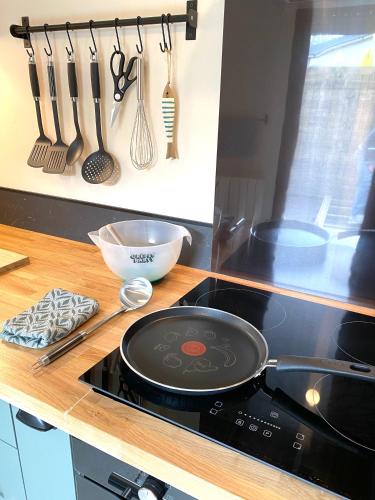 une cuisinière avec une poêle à frire sur un comptoir dans l'établissement Le cottage de Zoé, au Vivier-sur-Mer
