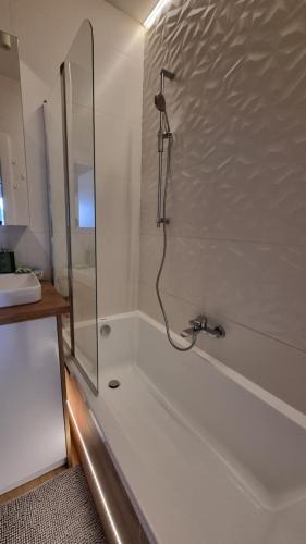 a bathroom with a shower and a bath tub at Apartament Bianco - Aquapark in Rumia