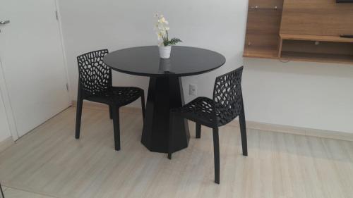 a black table with two chairs and a vase on it at AP ALPHA 5 STAr in Vespasiano