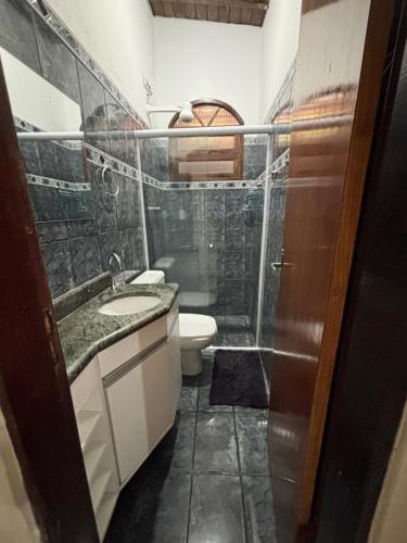 a bathroom with a toilet and a sink and a shower at Pousada da Árvore in Boicucanga