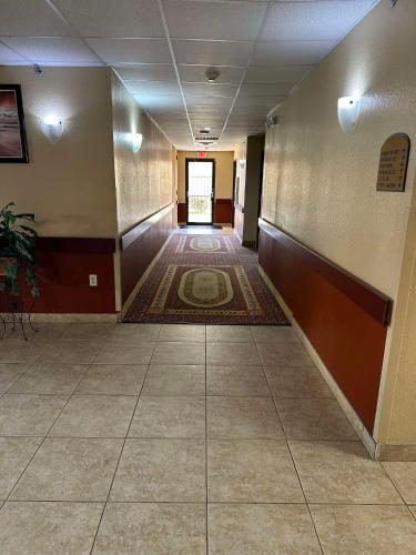an empty hallway with a tile floor in a building at Red Lion Inn & Suites IAH Airport East in Humble