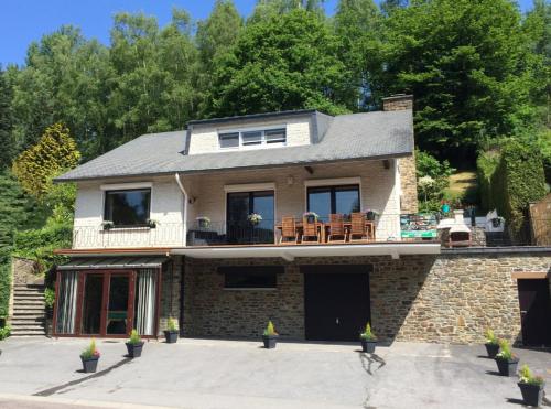 a large brick house with a patio on top of it at Balcons de la semois in Vresse-sur-Semois