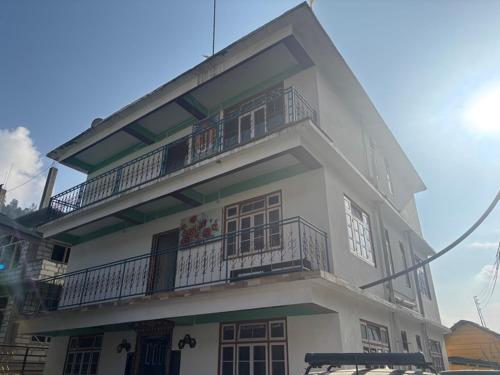 a white building with balconies on the side of it at Lachung Comfotel by Rare Himalayas in Lachung